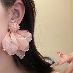 Detailed view of oversized pink chiffon flower earrings with crystal cluster top