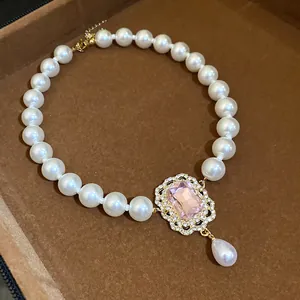 Primo piano di elegante collana di perle con ciondolo gemma rosa in stile vintage