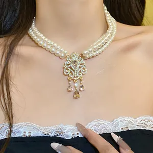 Dettaglio ravvicinato di una collana di perle multistrato vintage con pendente strass.