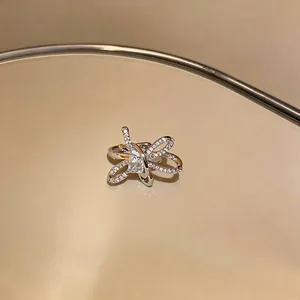Detailed view of a sparkling zircon-encrusted silver bow-shaped clip-on ear cuff