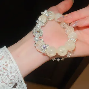Detailed macro shot of a luxury zircon and cream pearl beaded bracelet on a woman's wrist