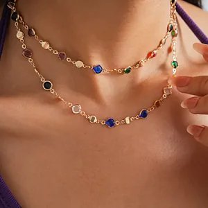 Close-up detail of a double-layered gold-tone necklace with vibrant multi-colored crystals.