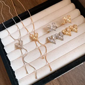 Close-up detail view of minimalist crumpled heart jewelry set in gold and silver finishes