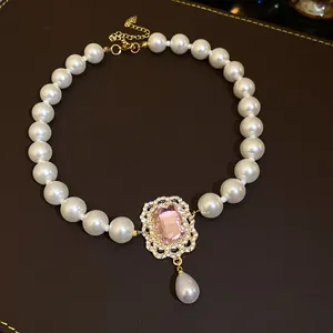 Dettaglio di collana di perle vintage francese con gemma rosa e pendente di diamanti