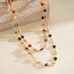 Macro view of gold chain necklace featuring colorful crystals and geometric discs