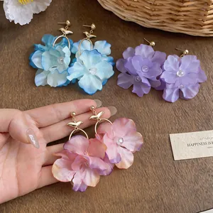 Elegant handmade fabric flower drop earrings in blue, purple, and pink floral designs.