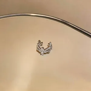 Close-up of elegant silver-toned ear cuff with sparkling zircon heart and cross details