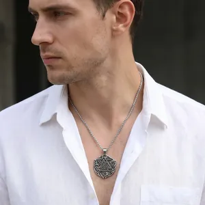 Viking Valknut rune pendant necklace on a male model wearing a white linen shirt