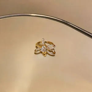 Detailed macro shot of an elegant gold butterfly-shaped ring with sparkling cubic zirconia.