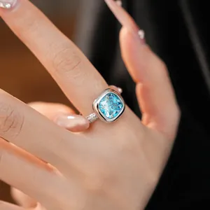 Dettaglio macro di un anello color argento con uno zircone blu chiaro taglio quadrato