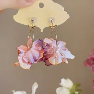 Close-up of pink fabric flower stud earrings with elegant petal details.