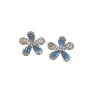 Elegant blue hollow flower stud earrings with sparkling crystal accents for women.