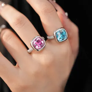Primo piano dettagliato di eleganti anelli con zirconi quadrati rosa e blu