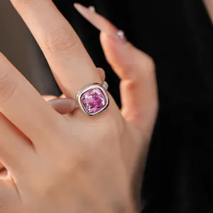 Dettaglio di un anello in argento di lusso con zircone rosa quadrato su mano di modella.