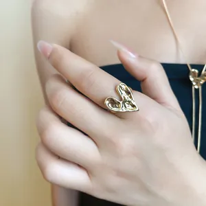 Close-up of molten heart ring with textured gold finish on hand