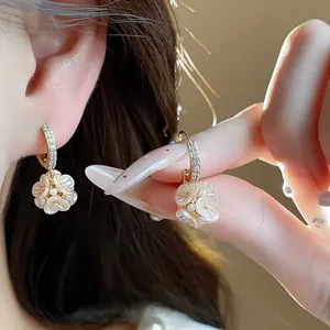 Detail shot of elegant zircon flower earrings featuring micro-pearls and French style