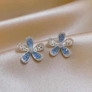 Close-up of elegant blue floral earrings with delicate crystal and pearl detailing