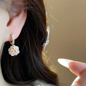 Close-up view of elegant French style floral drop earrings with zircons and pearls worn on ear