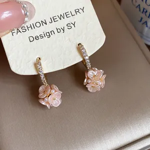 Macro detail of French style flower hoop earrings adorned with zircons and pearls