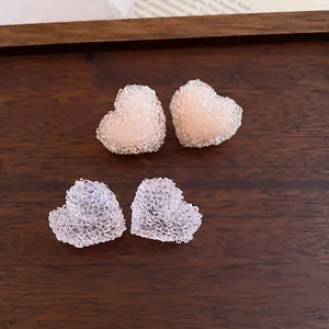 Macro detail of resin heart stud earrings with a unique sparkling jelly fragment texture