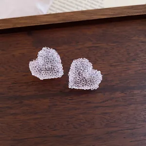 Detailed close-up of pink heart-shaped resin earrings with crushed ice texture
