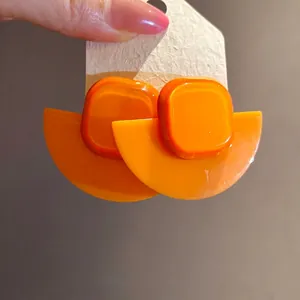 Vibrant orange resin fan-shaped earrings with square detail, vintage retro style.
