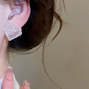 Detailed close-up showing texture of a pink jelly resin heart stud earring on model ear