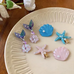 Detailed view of colorful marine-themed hair clips featuring shells, starfish, and pearls
