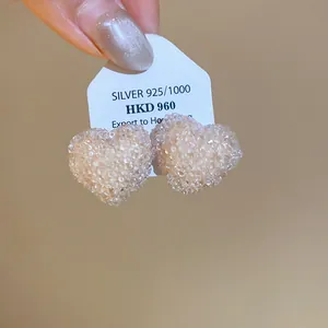 Close-up of heart-shaped resin stud earrings with crushed ice texture on a card