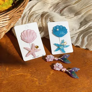 Detail of ocean-themed hair clips featuring starfish, shells, and mermaid tails