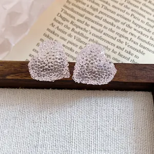 Close-up of pink heart-shaped resin stud earrings featuring a faceted crushed ice texture