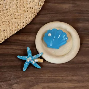 Detailed view of blue starfish and shell hair clips with pearls for beach styling.