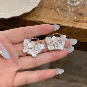 Exquisite detail of delicate flower earrings with pearls and crystals on silver needle