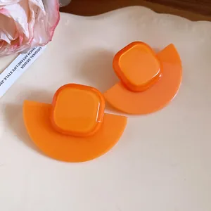 Detailed view of bright orange resin fan-shaped earrings with square accent