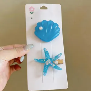 Detailed view of exquisite blue starfish and shell hair clips with a pearlescent finish