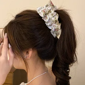 Vue détaillée d'une pince banane en tissu floral avec papillons en zircone