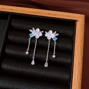Detailed shot of elegant flower tassel earrings with blue zircon in a jewelry box