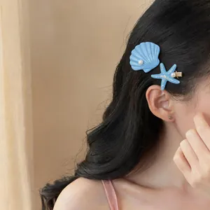 Close-up detail showing blue shell and starfish hair clips worn on long dark hair