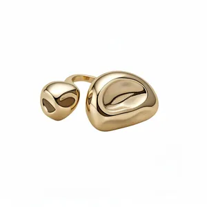 Anello aperto scultoreo irregolare color oro con una finitura in metallo lucido.