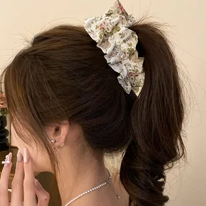 Vue détaillée d'une pince banane en tissu floral ornée de nœuds élégants en zircon