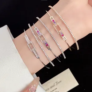 Close-up detail of luxurious 18k gold plated square zircon open bangles on a woman's wrist