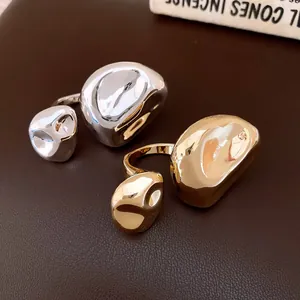 Vista dettagliata di anelli aperti a pieghe irregolari in finiture oro e argento