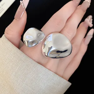 Primo piano di un anello aperto in argento lucido con design irregolare e stropicciato
