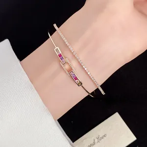 Close-up of 18k gold plated zircon square open bangle and tennis bracelet on wrist