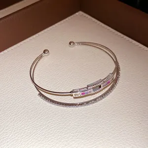 Detailed view of silver-tone double-layered open bangle with rainbow zircon stones