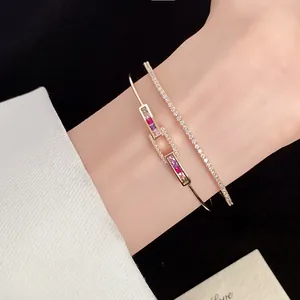 Detailed view of 18k gold plated open bangle with square zircons and sparkling bracelet