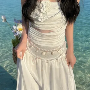 Detail of flower pearl tassel waist chain on a white vacation dress by the sea