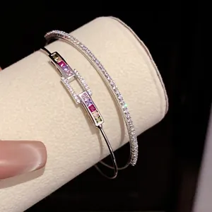 Close-up of 18k gold plated open bangles with colorful and white zircon inlay.