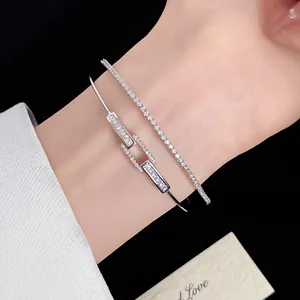 Close-up of 18k silver-plated zircon bangle and tennis bracelet on wrist.