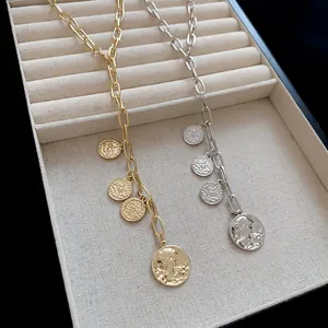 Macro view of gold and silver coin necklaces with embossed portrait pendants in display box
